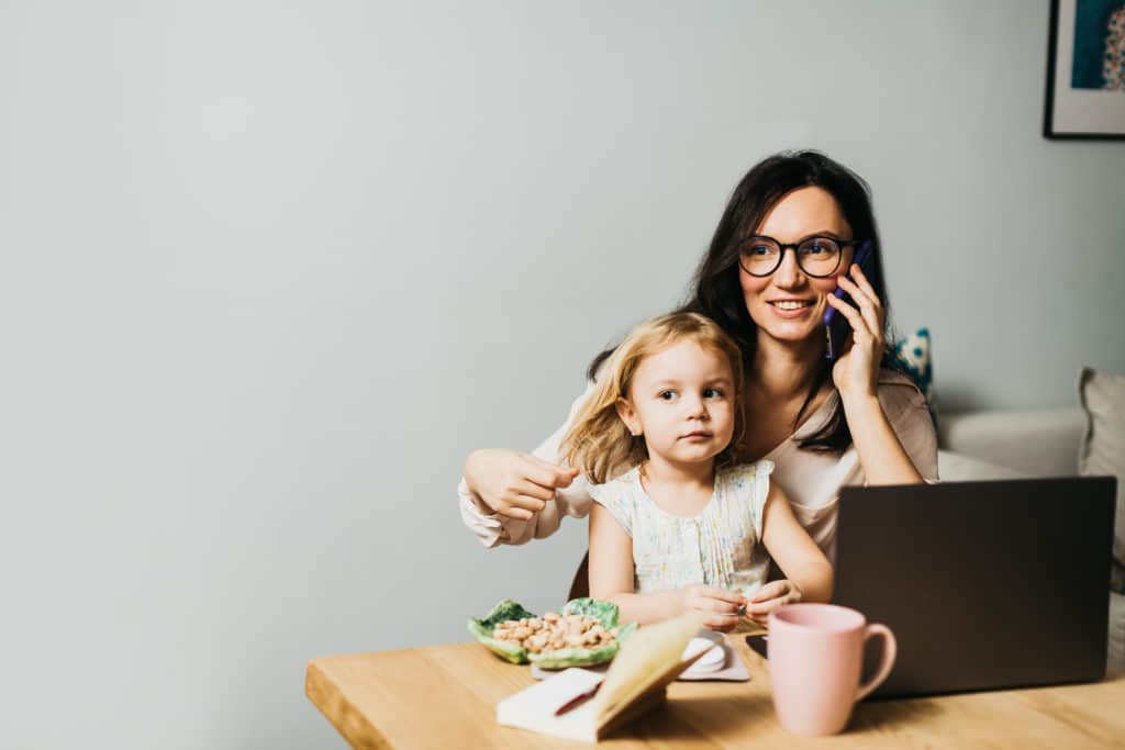 Woman Working at Home with Child in Her Lap