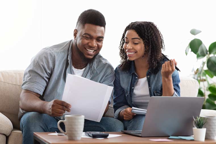 Young Man & Woman Reviewing Financial Documents at Home